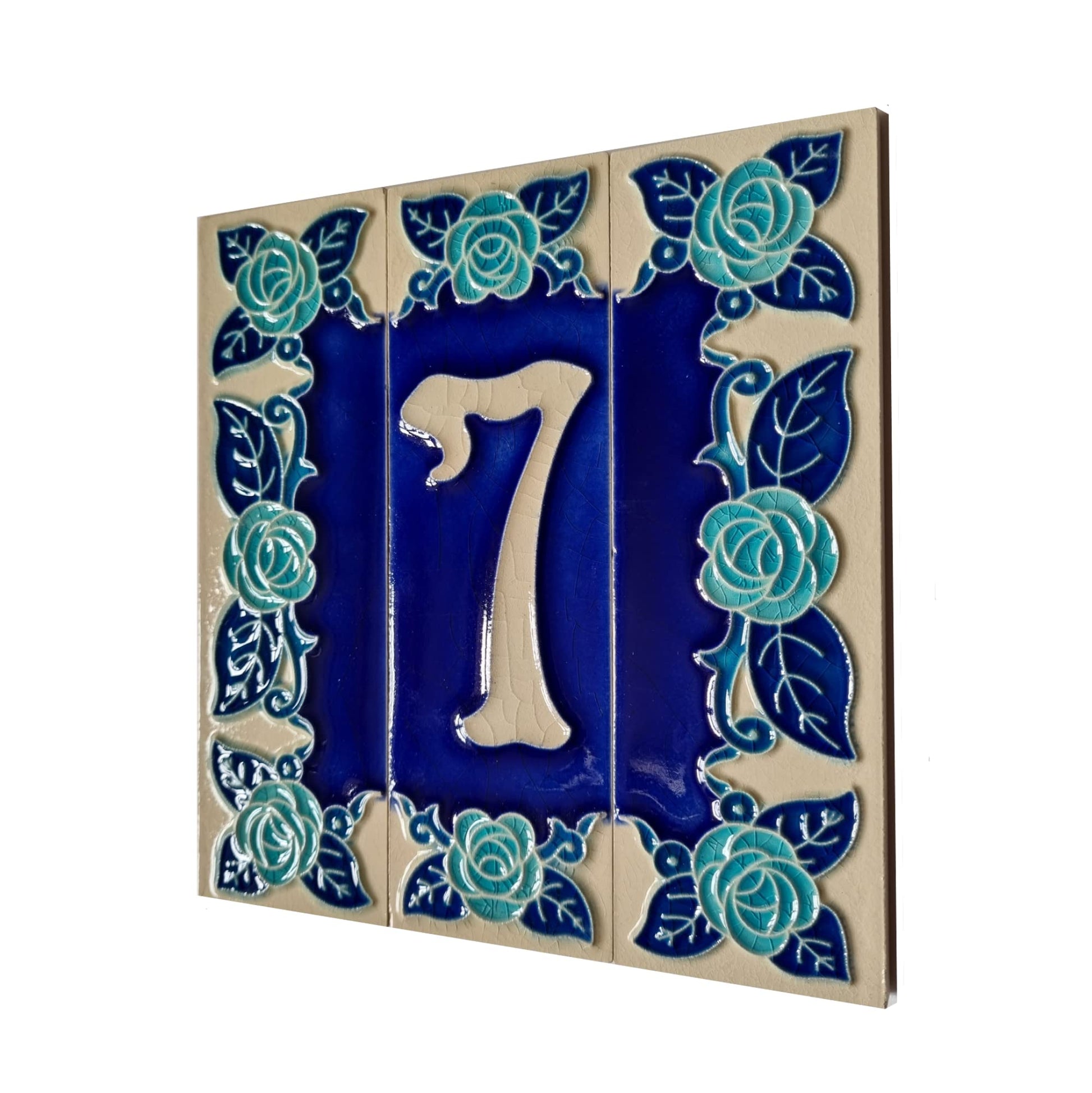 Ceramic tile with number 7 surrounded by floral designs on a white background